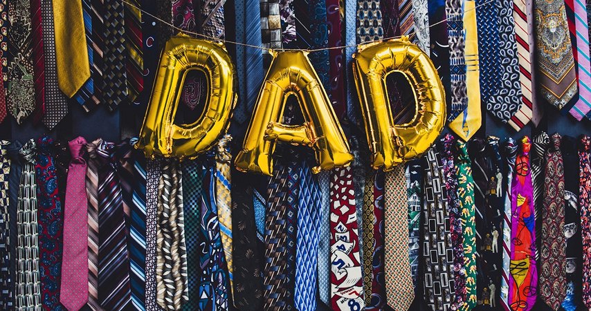 Photo of Dad with balloons with ties as a backdrop